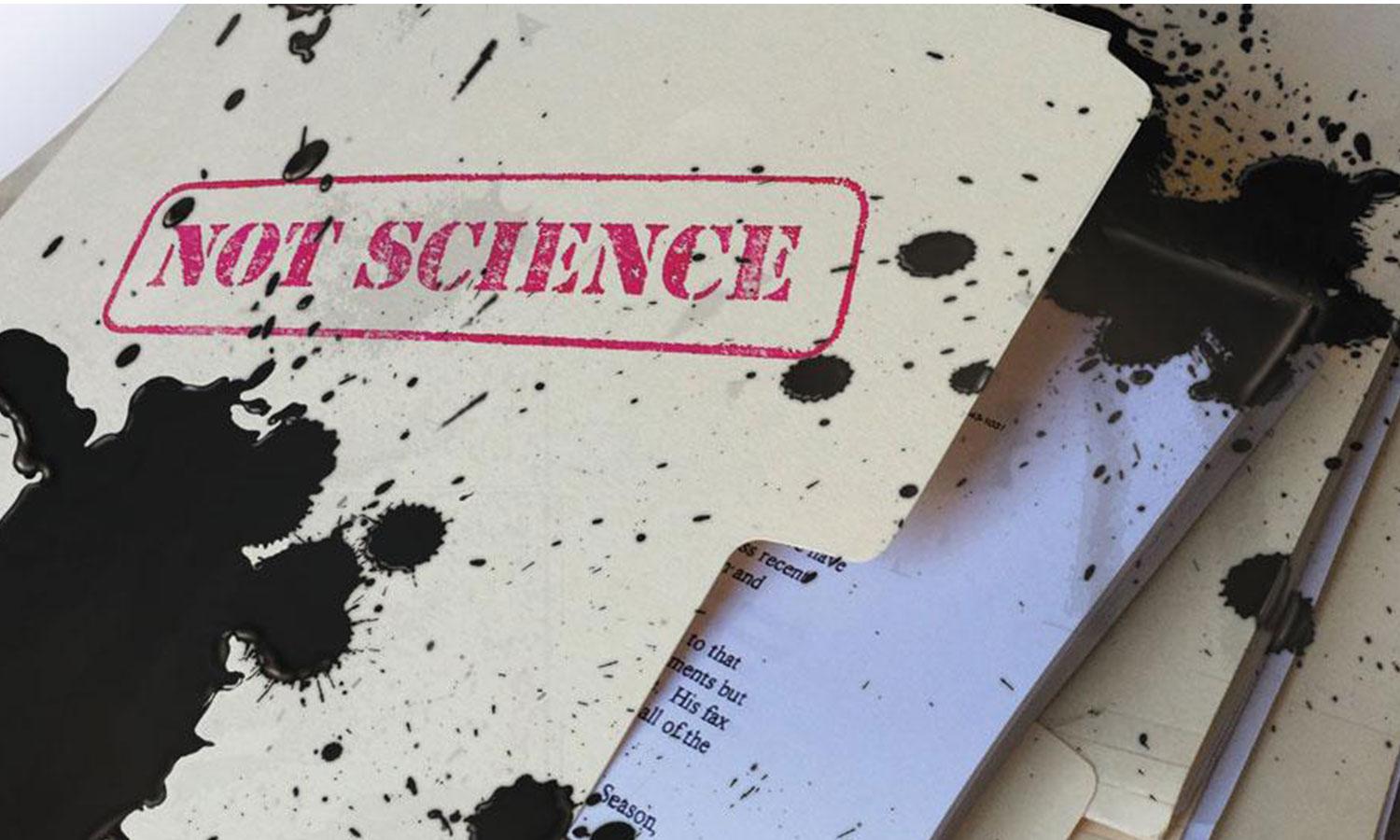 A file folder with red "not science" stamp covered in black oil