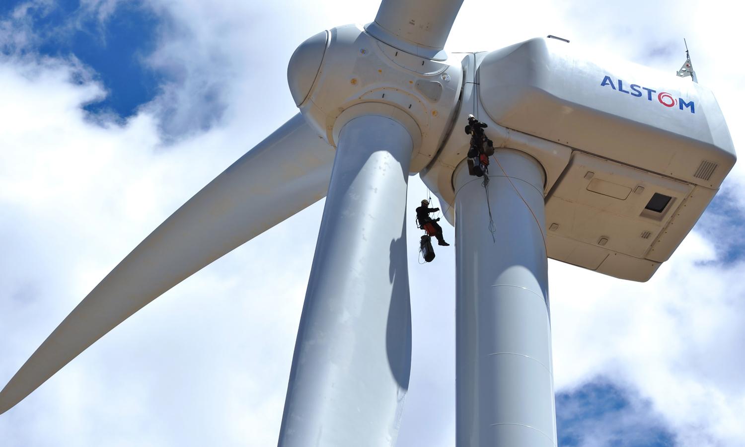 Two workers on the top of a wind turbine.