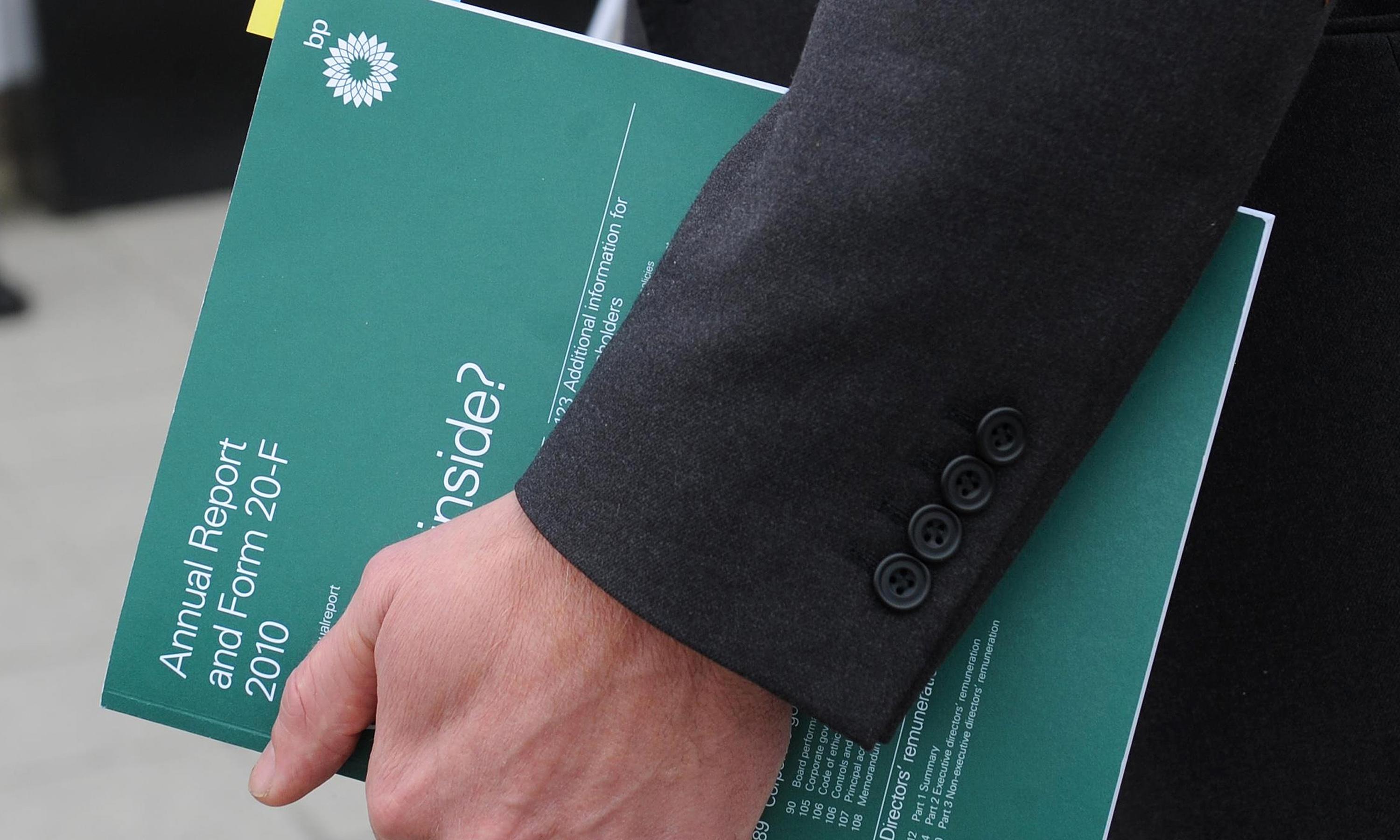 Person holding a BP annual report booklet.