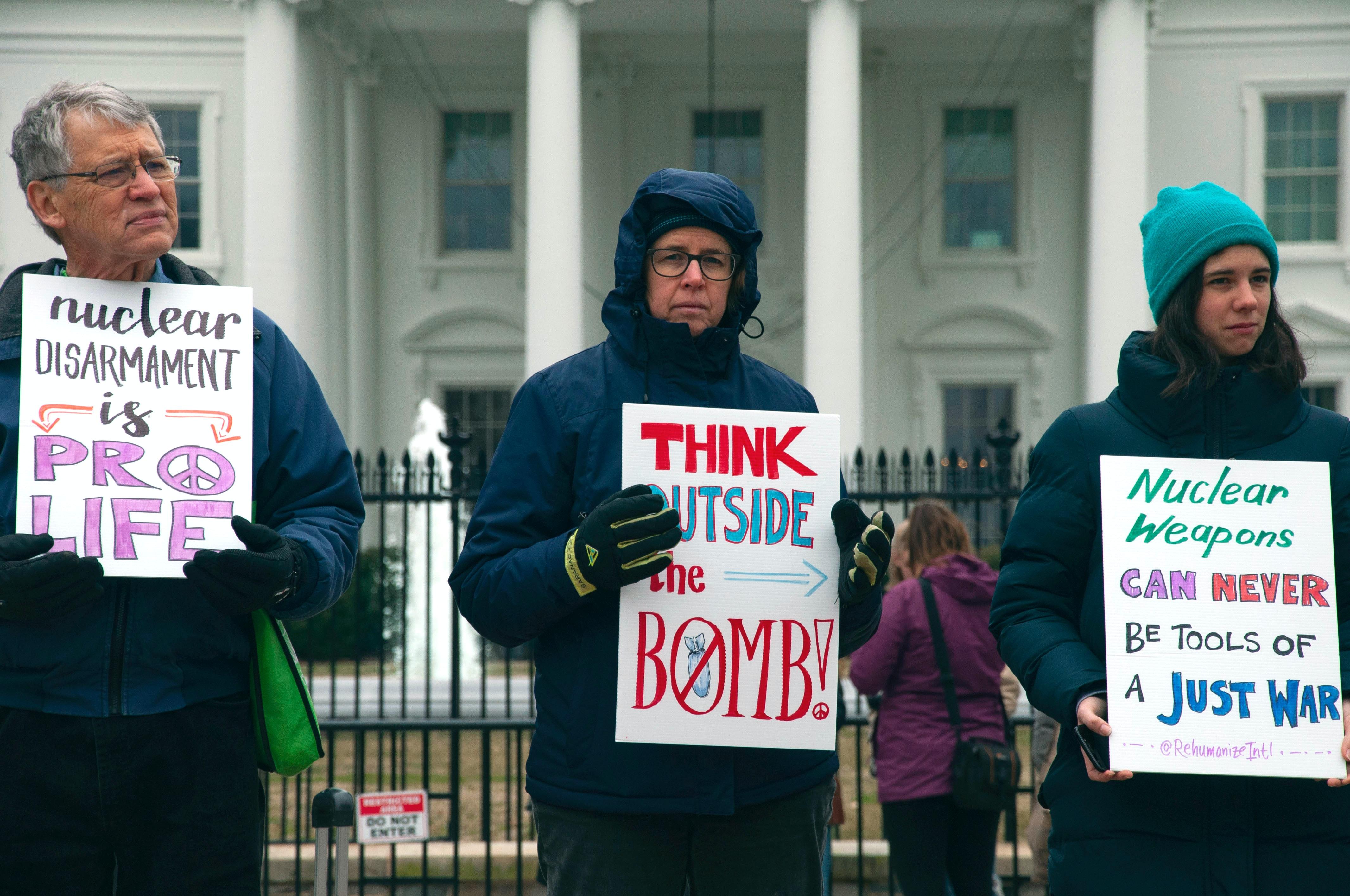 Man and two women protest nuclear weapons outside White House