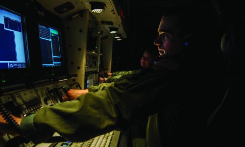 An instructor sits at missile launch controls during a simulation training