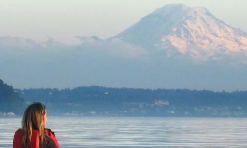 A kayaker looks out at Mount Rainier in Washington
