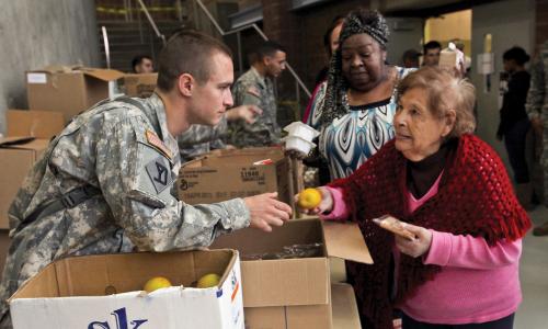 National guard soldier handing out fruit after Hurricane Sandy