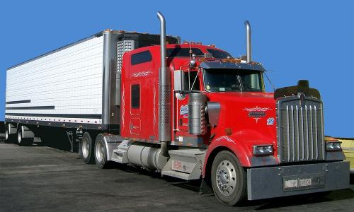 Red truck pulling white trailer