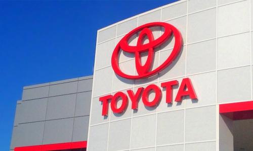 The red Toyota logo on exterior wall of one of its car dealerships