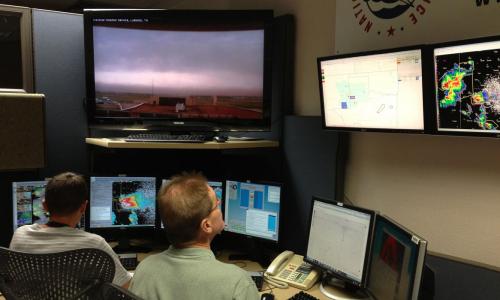 Two NWS scientists monitor the weather.