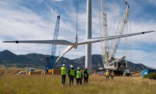 A wind turbine being erected with workers