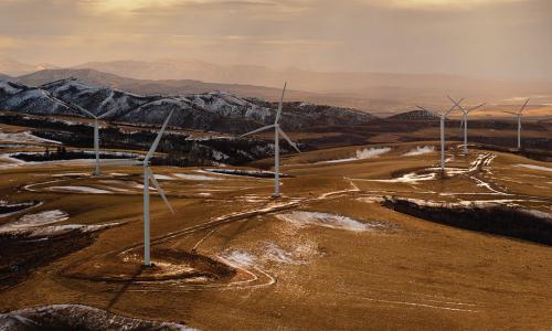 wind turbines on top of snowy desert mountains